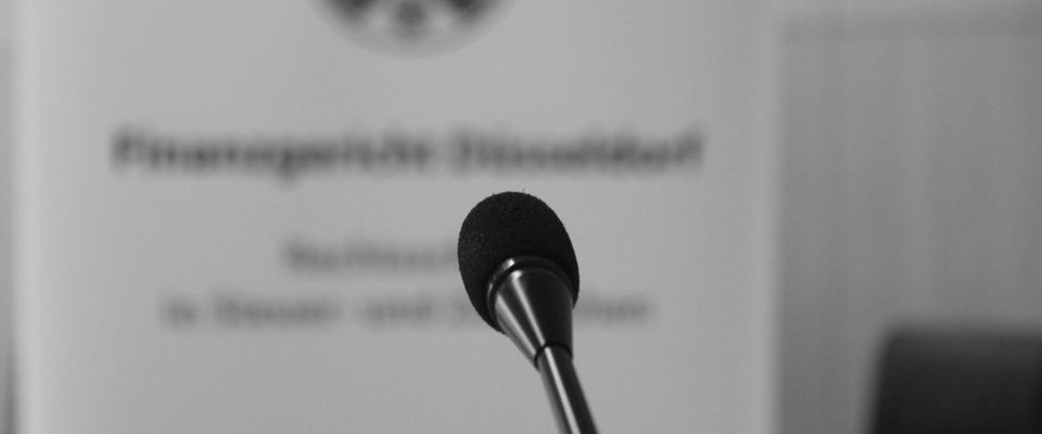 Mikrophon mit Banner im Hintergrund (schwarzweiß)
