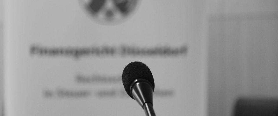 Mikrophon mit Banner im Hintergrund (schwarzweiß)